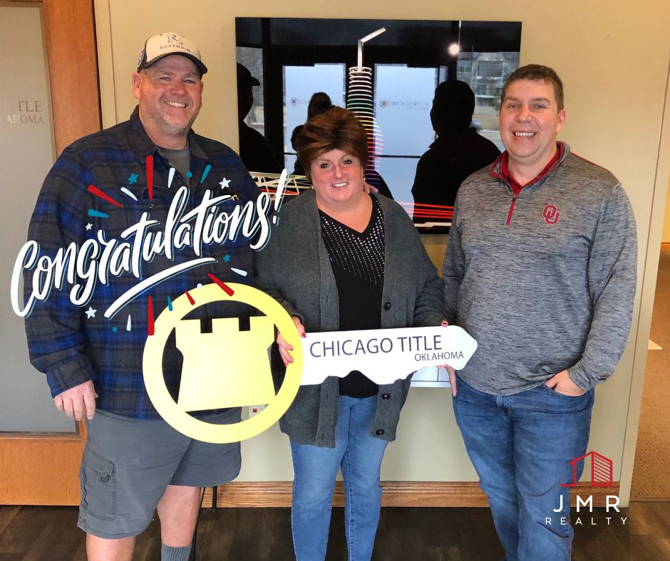 photo of real estate agent jimmy hughes standing with a male and a female who he recently helped close a real estate deal with.
