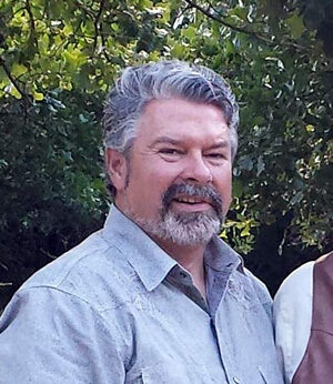 Photograph of robert helms with Edmond Kitchen and Bath, wearing a blue collar shirt and smiling.